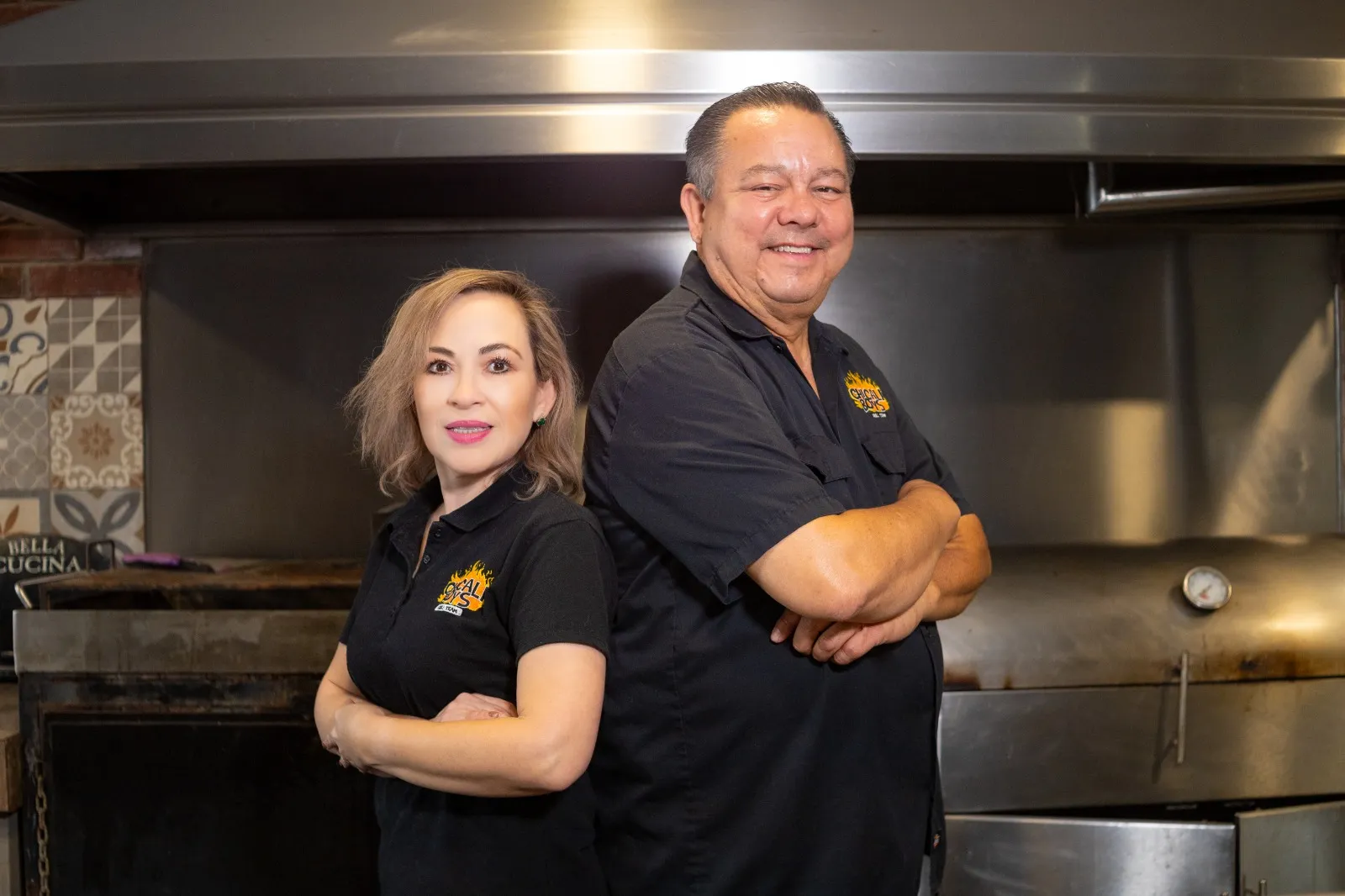 Dos integrantes de Chicali Boys posan sonriendo frente a la cocina.
